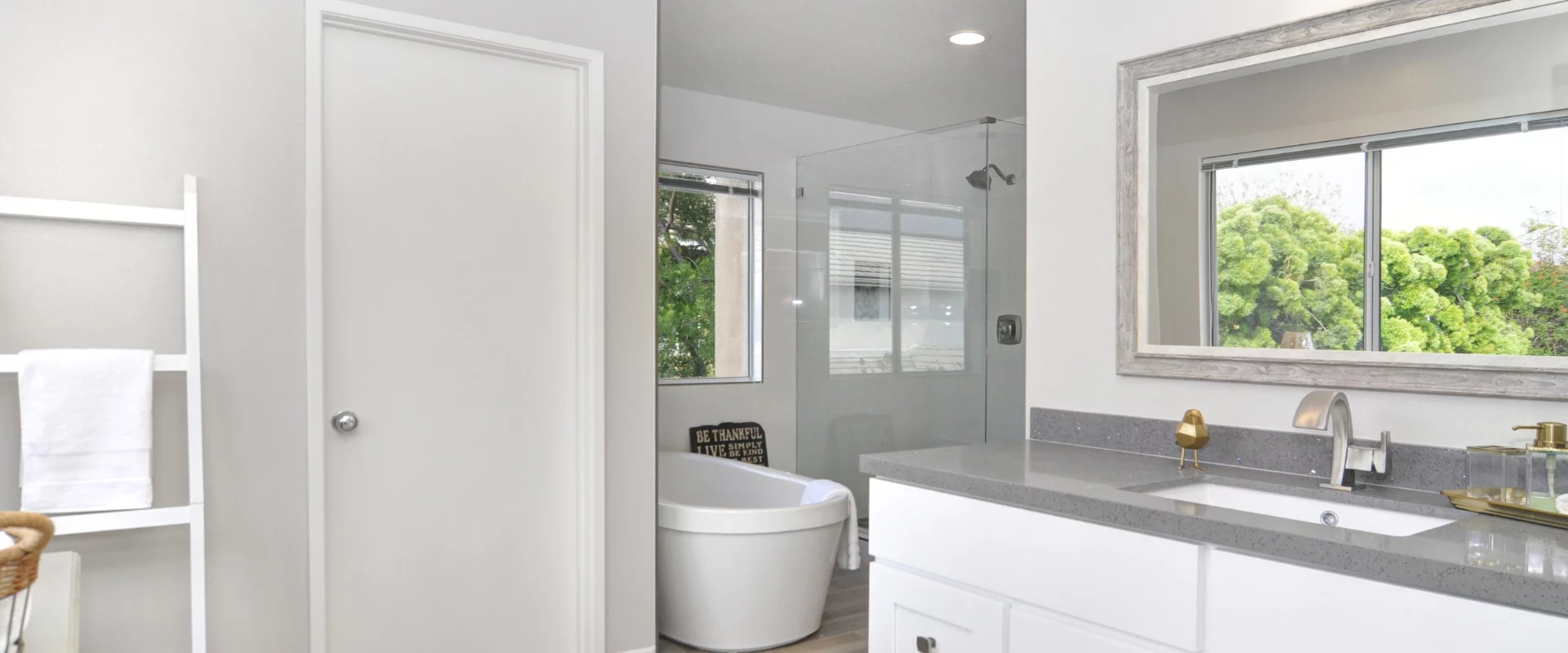 light grey bathroom with white cabinetry and a dark grey countertop